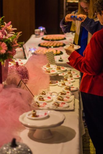 Guests admiring the pink desserts and trying them.