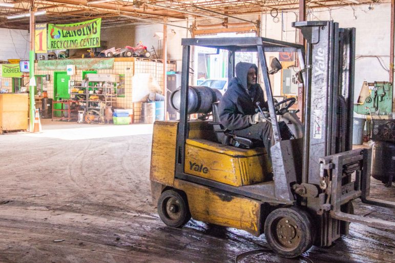 An employee of Lansing Recycling Center drives a forklift through their facility on Cedar Street on Dec. 12, 2018.
