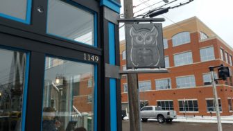 Blue Owl Coffee logo on a sign in front of the REO Town location.