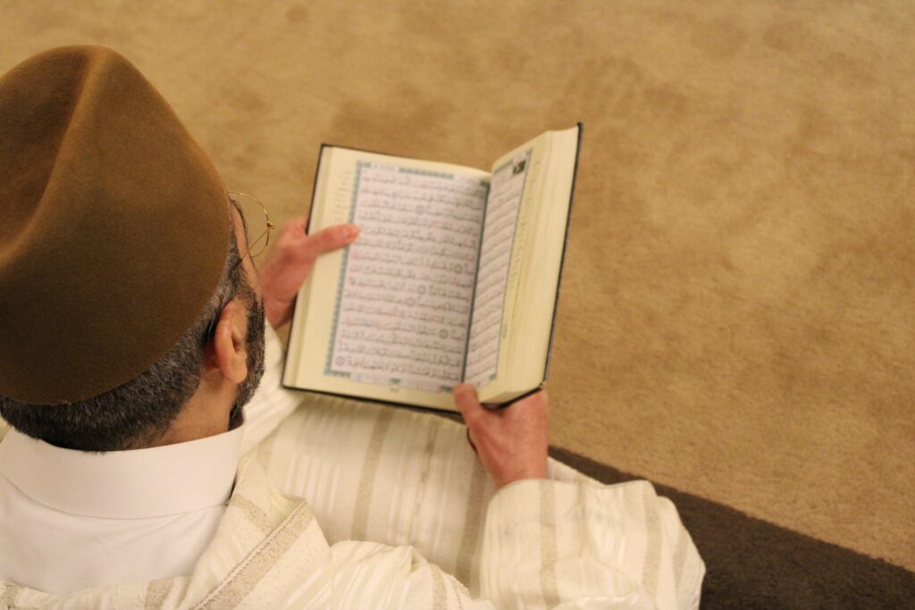 A lone man reads the Koran
