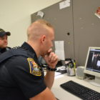 Officers Michael Lapham and Avery Lyon sit at the computer together