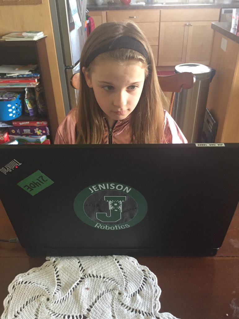 Third grade girl uses laptop.