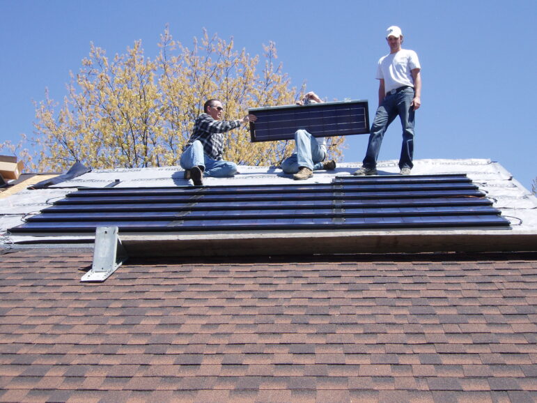 Installation of the roof-integrated solar panels on John Sarver’s East Lansing home in 2010. These were the only panels he used until 2019 when he added additional traditional style panels.