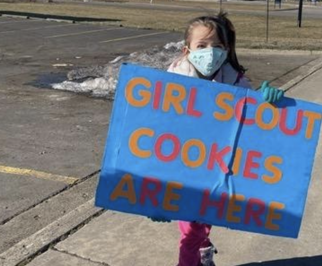 Girl Scout holds up sign