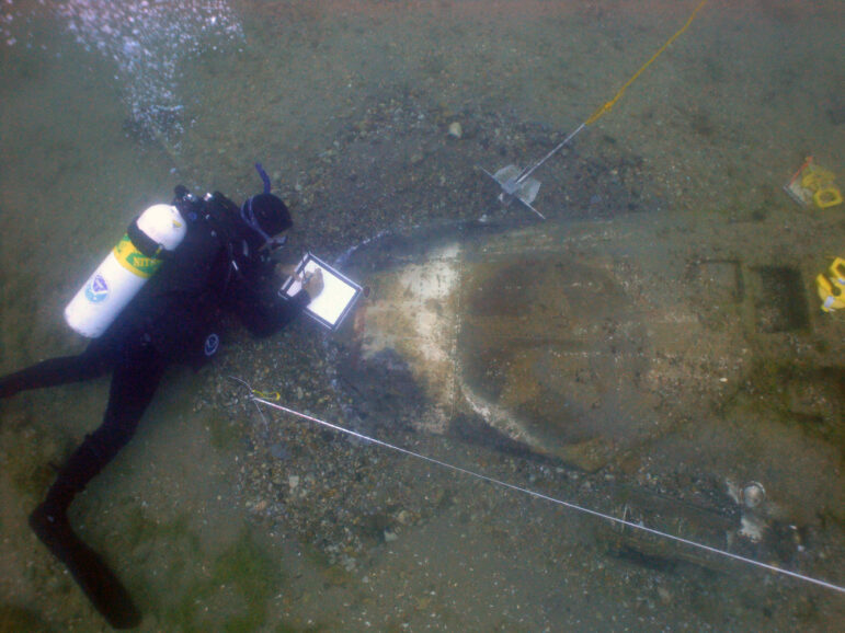 A scuba diver explores the wreckage of the lost P-39Q Airacobra at the bottom of Lake Huron.