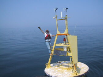 National Oceanic and Atmospheric Administration scientist Mike McCormick, co-author of a study on Lake Michigan’s deep water temperatures, stands on an instrument buoy in southern Lake Michigan.