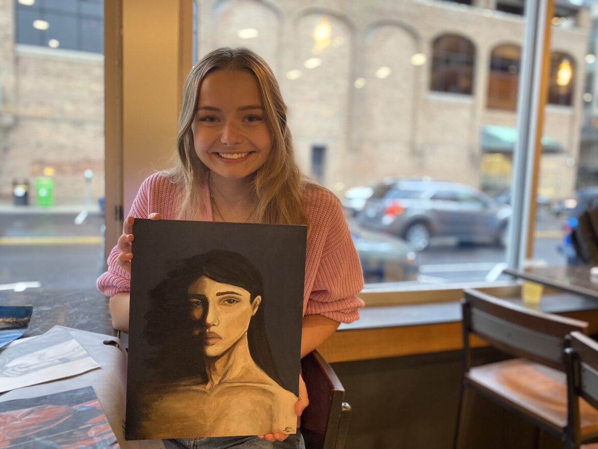 Ella Farlin poses with her painting, "Derealization."