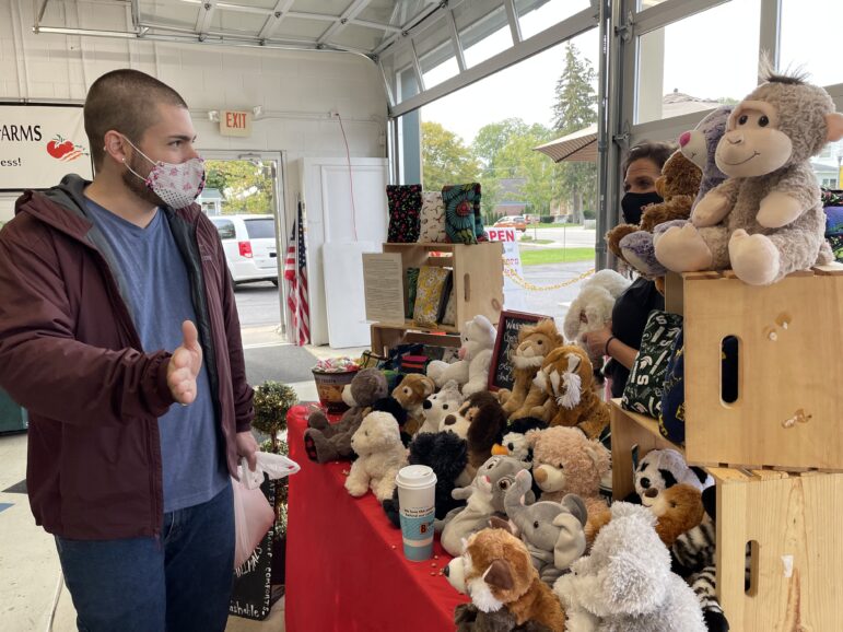 A customer talking to a stand-owner who sells stuffed animals.
