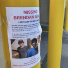 Brendan Santo missing poster pictured near a parking garage.