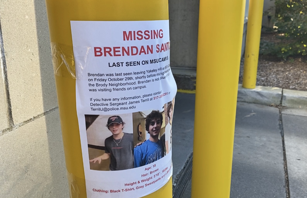 Brendan Santo missing poster pictured near a parking garage.