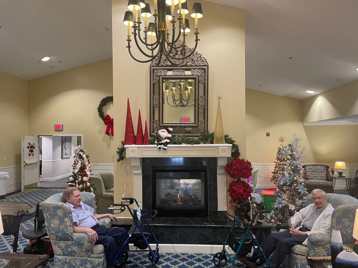 Residents at Independence Village in Grand Ledge talk surrounded by holiday decorations.