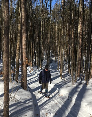A snowshoer on the trails of North Higgins Lake State Park