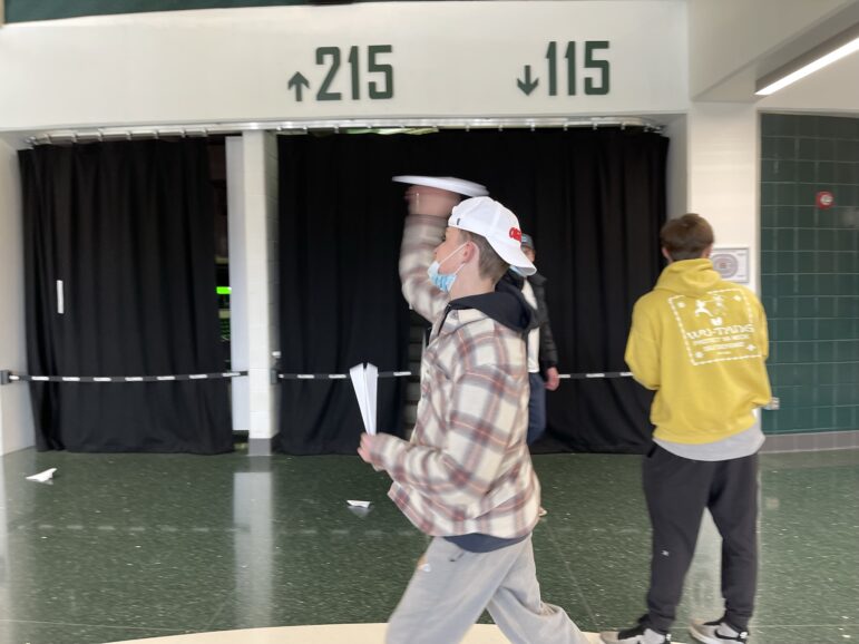 Student throwing paper airplane