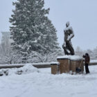 Man shovels around Sparty statue on MSU campus.