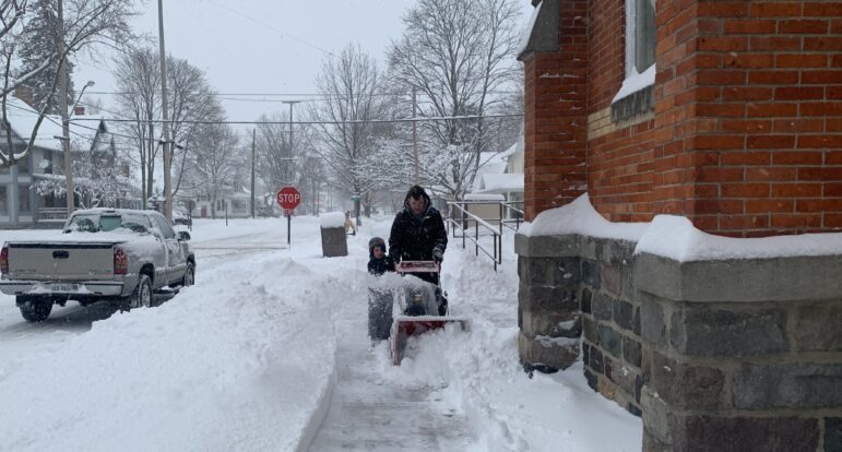 Man and boy with snowblower
