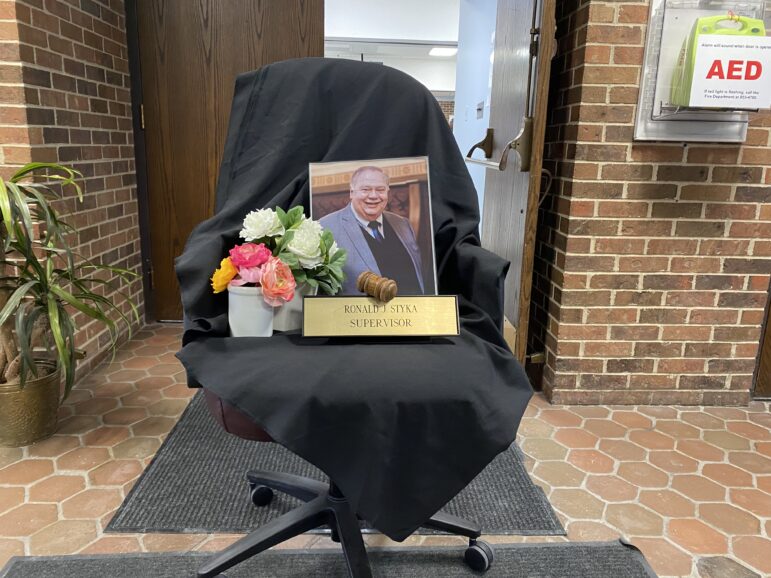 A small memorial to Ron Styka sits on a chair outside the township board meeting room