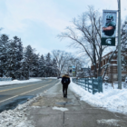 Students walks away from camera on sidewalk on snowy day