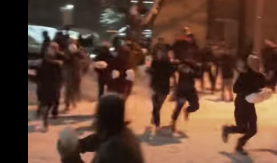 Michigan State students run through street with snowballs