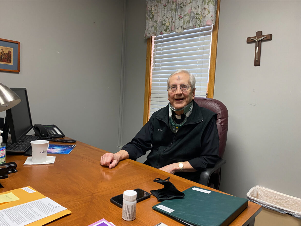 Pastor sits at his desk