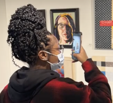 woman looks at cellphone in art gallery