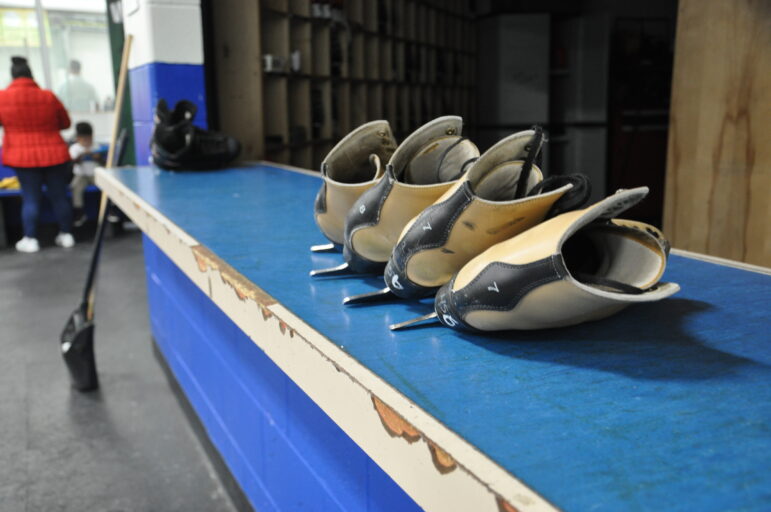 Two pairs of figure skates sit on the return counter of the rental shop at Suburban Ice in East Lansing.