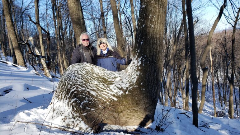 Dennis Downes and his wife, Gail Spreen, at a trail marker tree in La Crosse, Wisconsin.