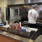 Man cooks at flat top grill