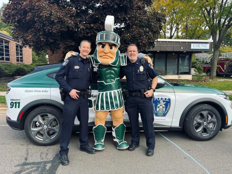 Interim Deputy Chief Chris Rozman (left) and Captain Dan Munford (right) pose with Sparty during the homecoming parade.