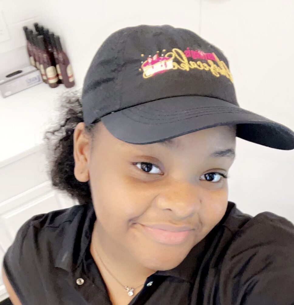 16-year-old Deasia Ray wearing her Everything is Cheesecake ball cap.
