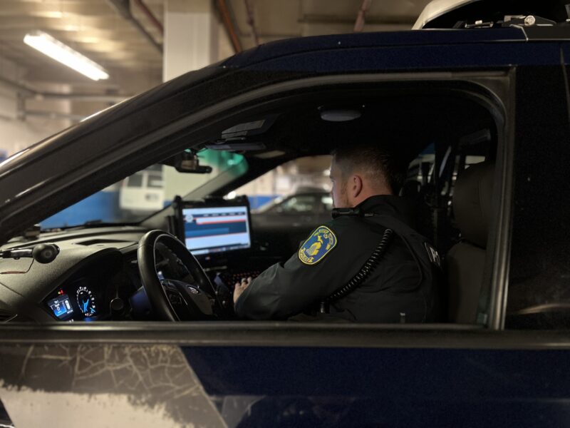 Lansing Community Service Officer Glenn Briggs scrolls through the city’s website while in his police vehicle.