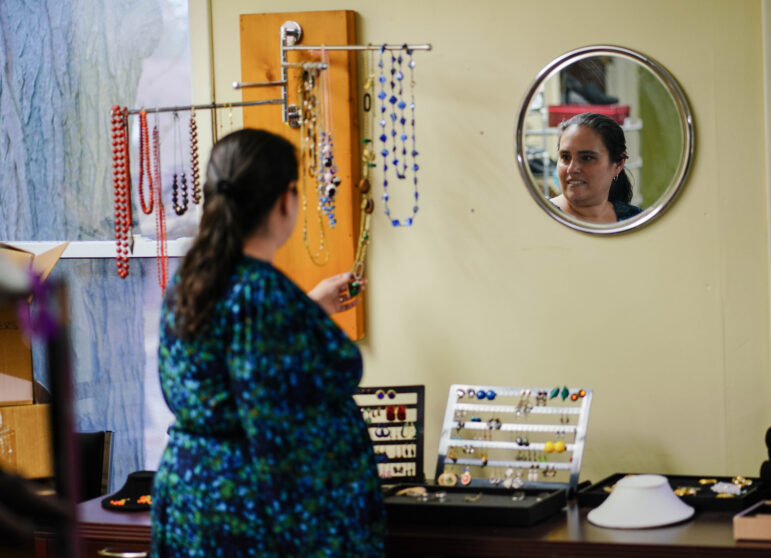 Rebecca Kasen, executive director of the Women’s Center of Greater Lansing, looks at the jewelry displayed in the center’s professional closet.