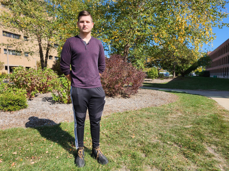 Yuri Tomkiw, founder of the Ukrainian Student Organization at Michigan State University, stands in front of trees and landscaping.