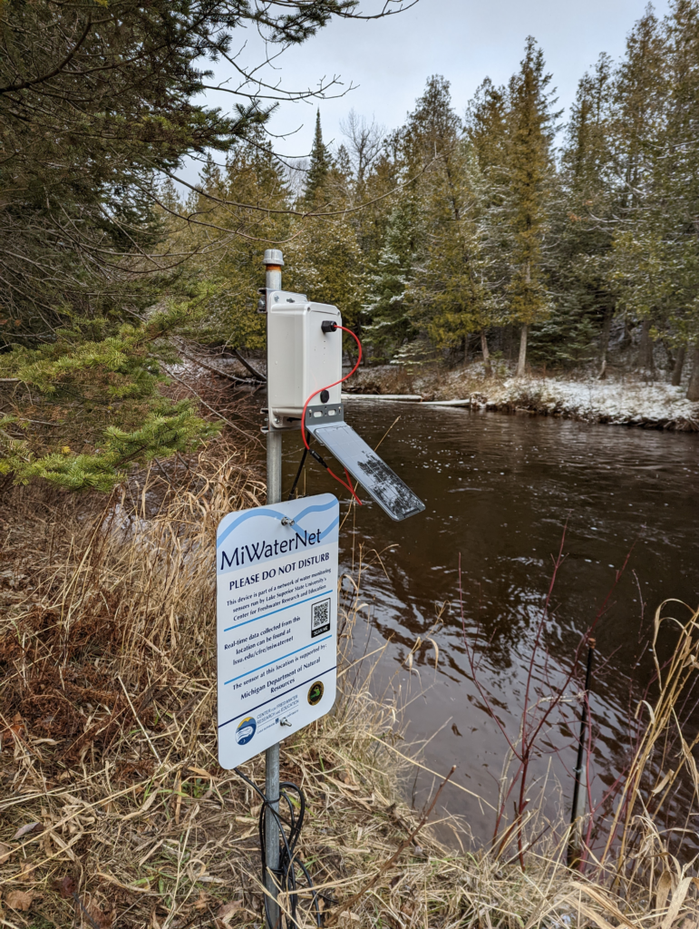 A sensor cable runs from the solar-powered controller of a monitoring station into the Carp River near Negaunee.