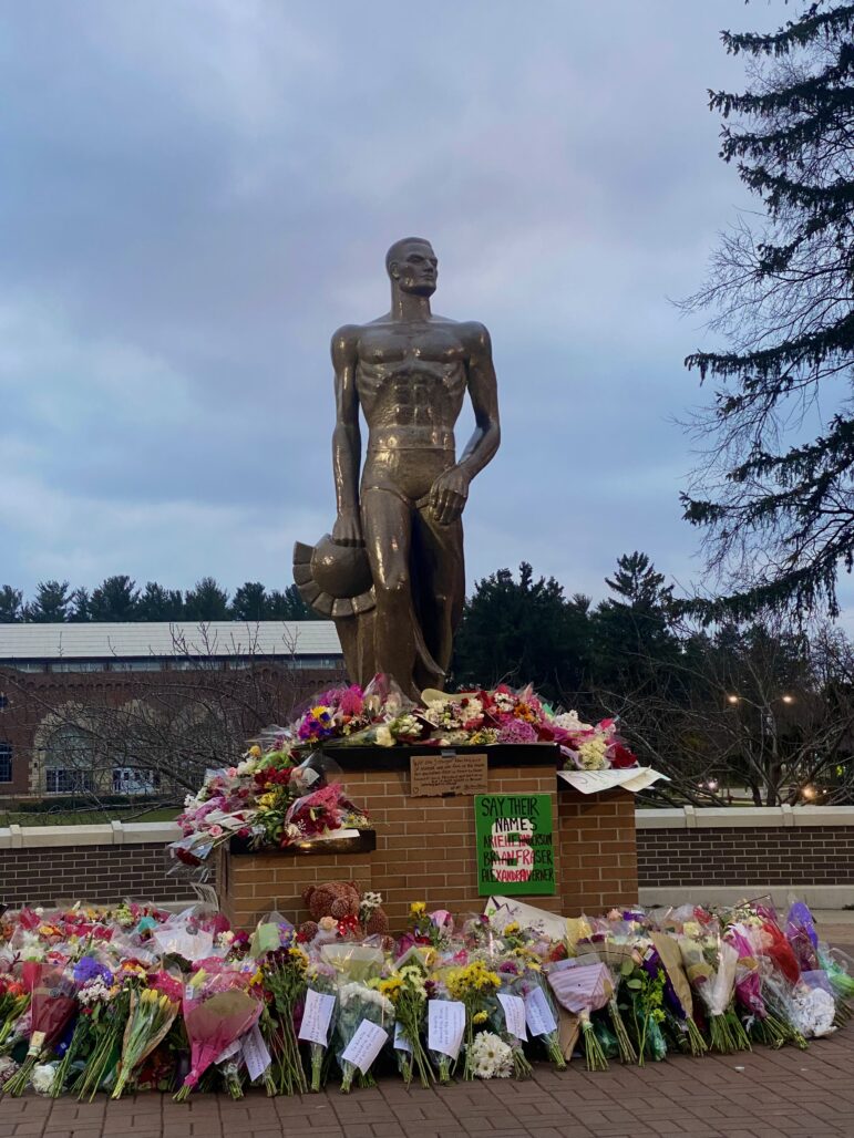 The Spartan Statue surrounded by bouquets and messages to the victims