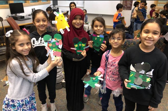 Students hold up their art models they made in Friends of the Earth class.