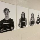Posters of students holding chalkboards with insults line a school wall.