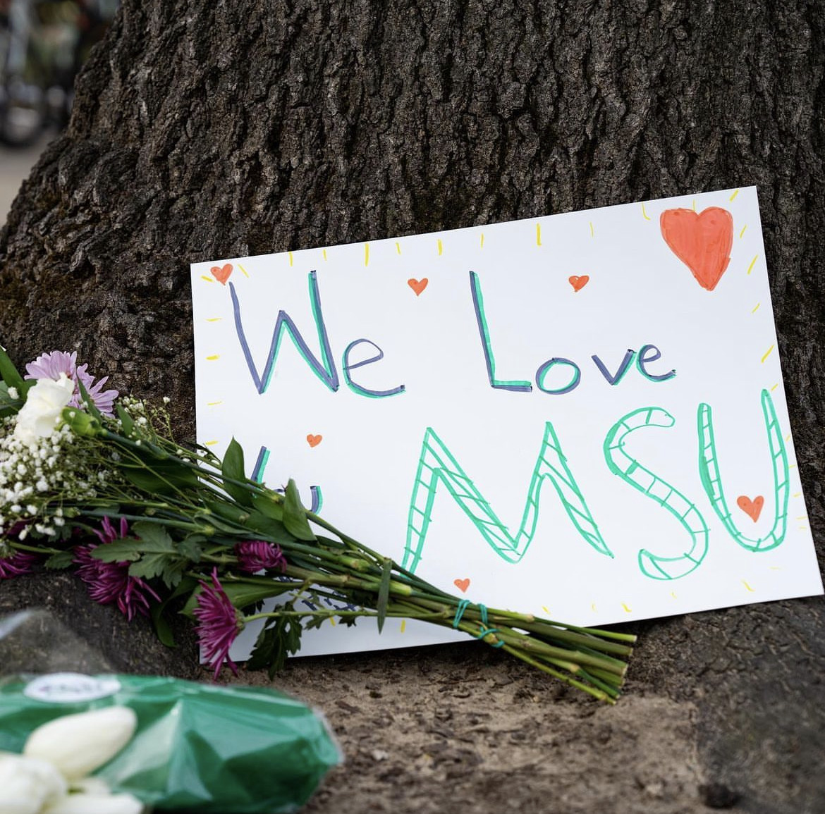 Notes of encouragement placed with flowers on the campus at Michigan State University.