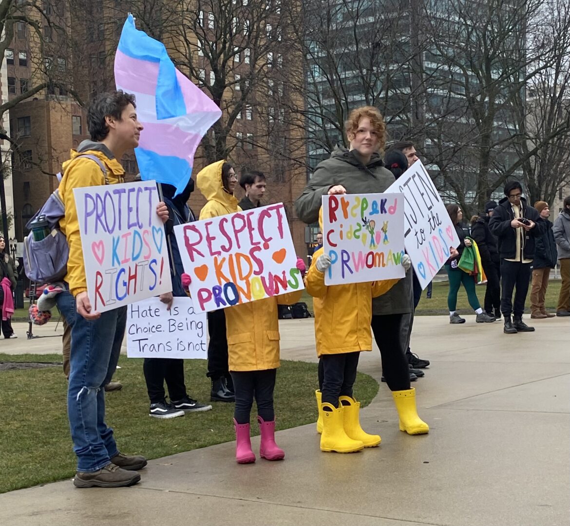 A family of four with homemade signs made by each family member that say "protect kids rights"