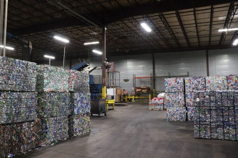Aluminum cans and bottles are pressed into bricks of recyclable material, waiting to be shipped and formed into new beverage containers.