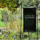 The “Nurture Your Roots” program sign anchors itself amongst the presence of wildlife and greenery within the Botanical Garden.