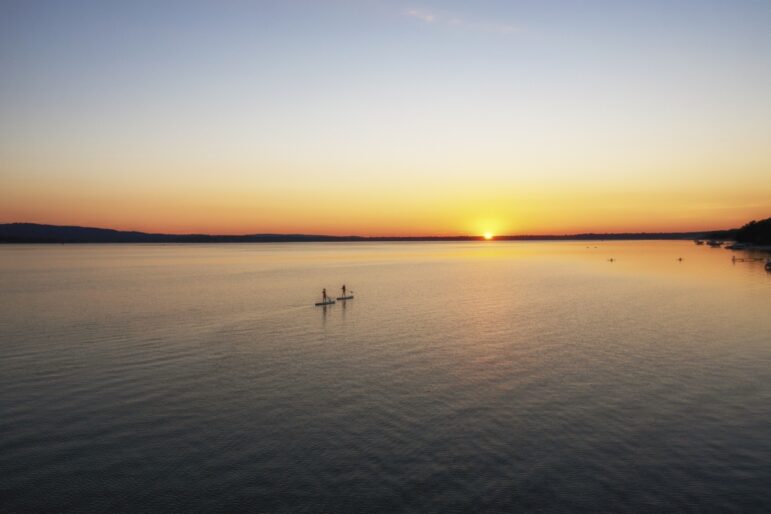 Paddle boarders cross Platte Lake where a decades-long campaign reduced algal blooms caused by runoff from a fish hatchery.